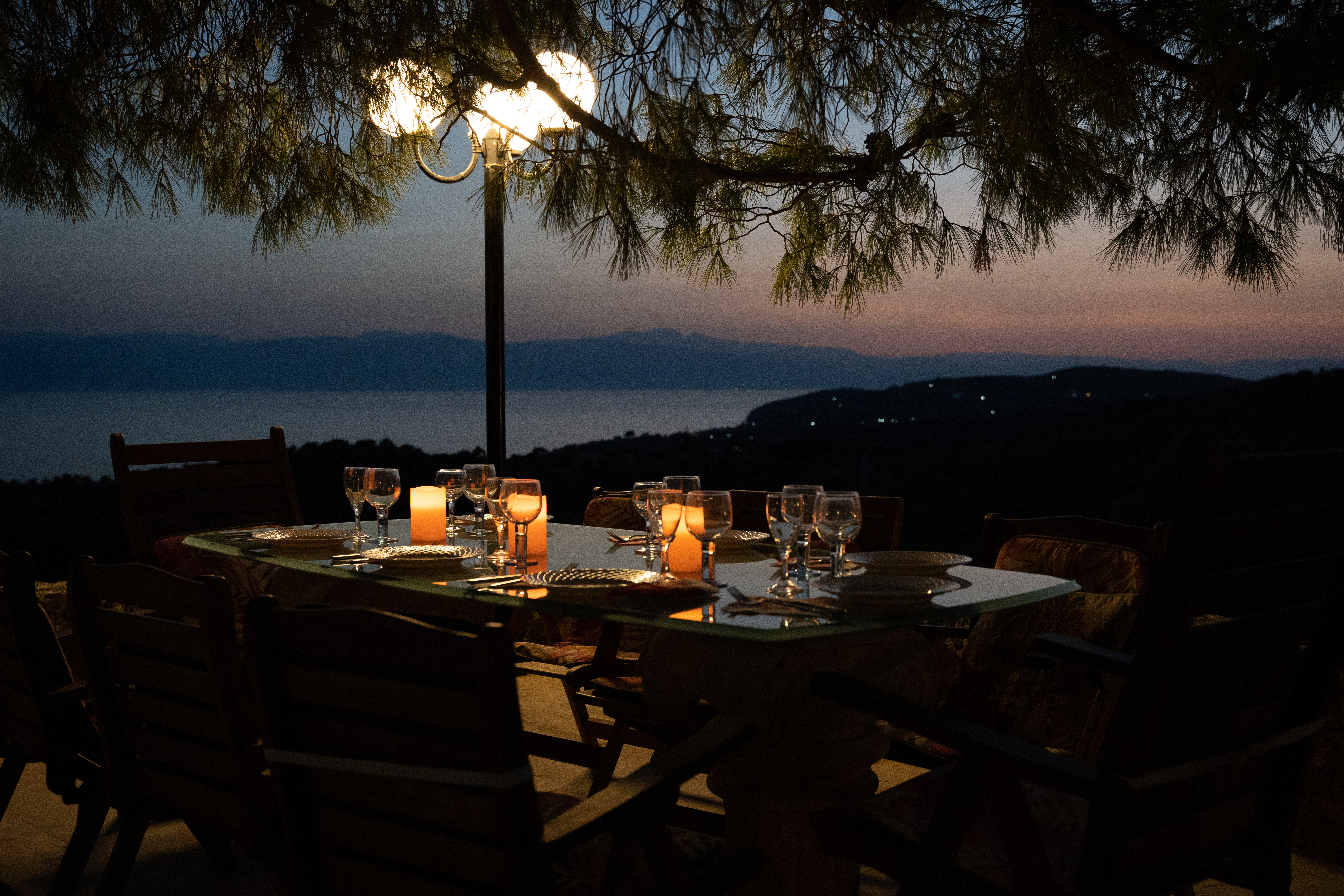Outdoor dining area at sunset beside the Poolside House